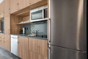 Kitchen with appliances with stainless steel finishes, open shelves, modern cabinets, and light brown cabinets