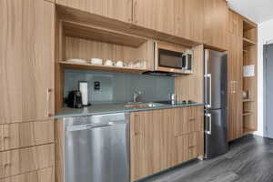 Kitchen with open shelves, modern cabinets, stainless steel appliances, and dark wood-style flooring