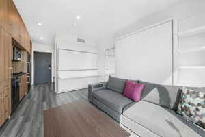 Living area with dark wood finished floors and recessed lighting