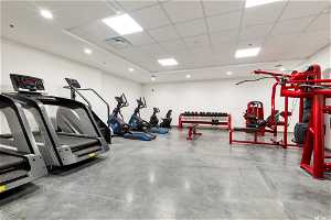 Workout area with a drop ceiling and concrete floors