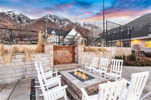 Patio terrace at dusk featuring a mountain view and a fire pit