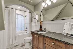 Full bathroom featuring vanity, toilet, shower / bath combo with shower curtain, and  marble floors
