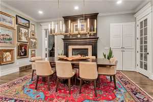 Dining space with dark wood flooring and crown molding