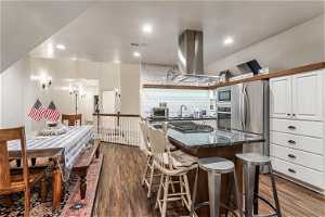 Kitchen featuring island range hood, backsplash, sink, dark hardwood / wood floors, and appliances with stainless steel finishes