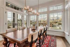 Sunroom / solarium with a chandelier and french doors