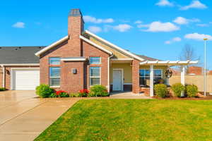Digitally enhanced view of front of house with a front yard, a chimney, driveway, and brick siding.