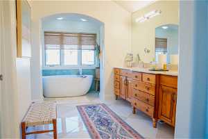 Bathroom featuring a wealth of natural light, dual sinks, tile floors, and oversized vanity