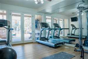 Workout area with light hardwood / wood-style flooring, ceiling fan, and french doors