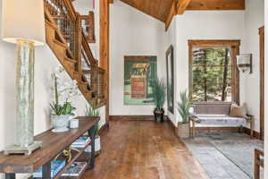Entryway featuring high vaulted ceiling, beam ceiling, and hardwood / wood-style flooring