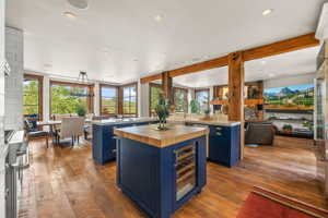 Kitchen featuring blue cabinetry, wine cooler, light hardwood / wood-style floors, and a kitchen island