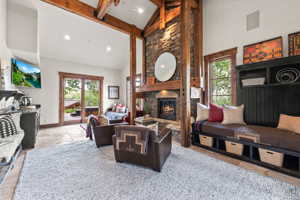Living room with beam ceiling, high vaulted ceiling, a fireplace, and hardwood / wood-style floors