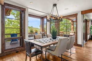 Dining space with a notable chandelier, plenty of natural light, and light hardwood / wood-style flooring