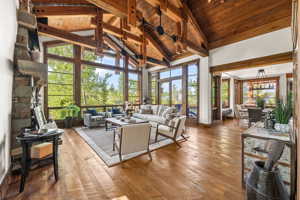 Living room with high vaulted ceiling, a healthy amount of sunlight, wood ceiling, and wood-type flooring