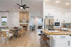 Kitchen with white cabinetry, ceiling fan, a fireplace, and high quality fridge