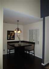 Dining area with dark hardwood / wood-style flooring and a notable chandelier