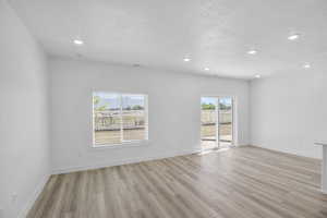 Living and Dining rooms featuring light wood-type flooring and a sliding door to semi private patio.