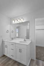 Bathroom featuring hardwood / wood-style flooring, dual vanity, and a window