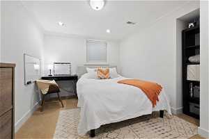 Bedroom with light carpet and ornamental molding