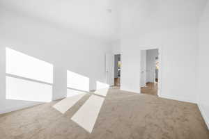 Unfurnished bedroom with light carpet and baseboards