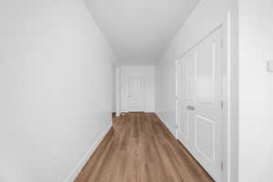 Hallway with wood finished floors and a textured ceiling