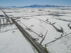 Snowy aerial view with a mountain view and a rural view