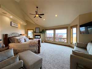 Bedroom with light colored carpet, high vaulted ceiling, and ceiling fan