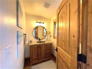 Bathroom featuring hardwood / wood-style floors, vanity, and a textured ceiling