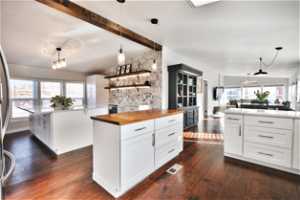 Kitchen featuring white cabinetry, dark hardwood / wood-style floors, a kitchen island, and plenty of natural light