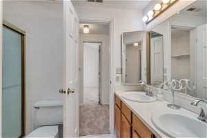 Bathroom with dual sinks, large vanity, and toilet