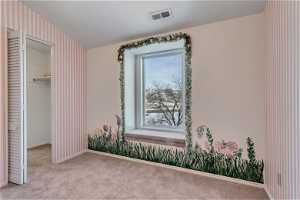 Carpeted bedroom with multiple windows, and a spacious closet