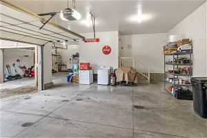 Garage with washing machine and clothes dryer and a garage door opener