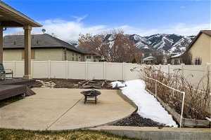 View of patio with a mountain view and an outdoor fire pit