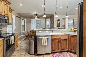 Kitchen featuring hanging light fixtures, sink, ceiling fan, and stainless steel appliances