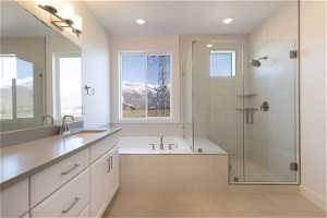 Bathroom featuring independent shower and bath, tile flooring, a mountain view, and vanity