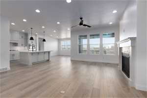 Unfurnished living room with light hardwood / wood-style flooring, ceiling fan, and sink