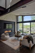 Living area with expansive windows, healthy amount of natural light, a fireplace, and wood finished floors