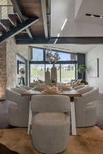 Living room featuring plenty of natural light, stairs, beamed ceiling, and wood finished floors