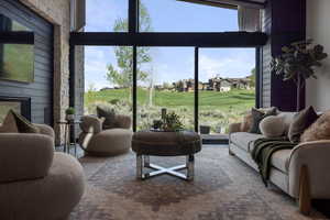 Living area featuring golf course view, healthy amount of natural light, and expansive windows