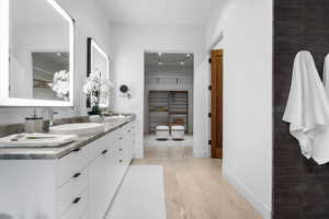 Full bathroom with double vanity and baseboards
