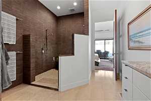 Bathroom featuring tiled shower and tile flooring