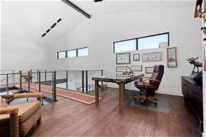 Office space with dark hardwood / wood-style floors, beam ceiling, and high vaulted ceiling