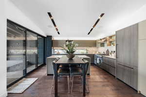 Kitchen featuring modern cabinets, under cabinet range hood, open shelves, and high end range