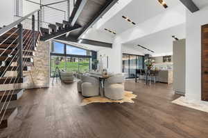 Dining space with wood finished floors, high vaulted ceiling, and beamed ceiling