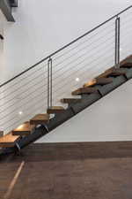 Staircase with wood finished floors and baseboards