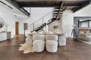 Dining space with stairway, wood ceiling, a glass covered fireplace, baseboards, and beam ceiling