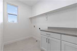 Laundry room featuring washer hookup, cabinets, light tile floors, and electric dryer hookup