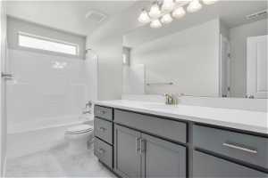 Full bathroom with tile flooring, vanity, toilet, and shower / tub combination