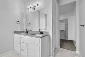 Bathroom featuring tile floors and double sink vanity