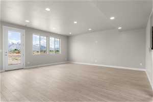 Empty room with plenty of natural light and light hardwood / wood-style flooring