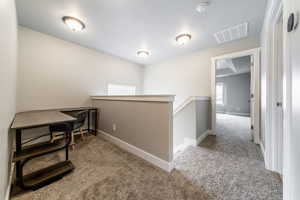 Hall with light carpet and a textured ceiling